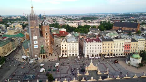 Drone-shot-of-Basilica-of-Saint-Mary-tower-restoration-construction-in-Main-Market-Square-in-Krakow-surrounded-by-buildings