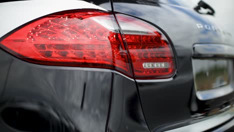 Close-up-of-a-Porsche-car's-red-taillight-in-daylight,-focus-on-intricate-LED-details