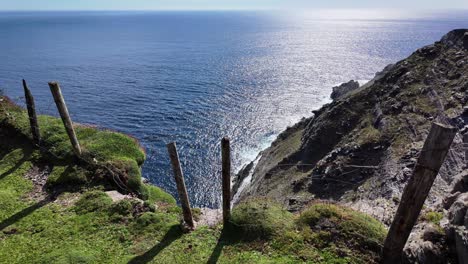 Ireland-Epic-locations-Sheeps-Head-West-Cork-coastal-erosion,-cliff-face-falling-into-the-sea-fencing-now-in-danger-on-a-bright-summer-day