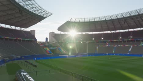 UEFA-EURO2024-Empty-football-stadium-with-sunlit-pitch-and-seats-in-Berlin-Drone-Shot