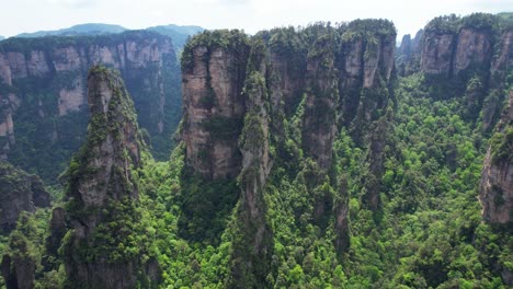 Toma-Aérea-Ascendente-Sobre-Yuanjiajie-Frente-A-La-Montaña-Aleluya-En-Un-Día-Soleado-En-China