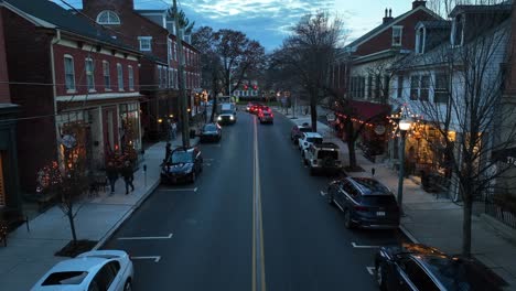 People-walking-on-sidewalk-and-shopping-in-decorated-shops-of-american-town