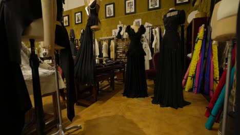 Dolce-And-Gabbana---A-fashion-design-workshop-featuring-elegant-black-dresses-on-mannequins,-with-various-fabrics-and-sewing-materials-in-the-background