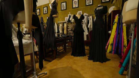 Dolce-Y-Gabbana:-Un-Taller-De-Diseño-De-Moda-Que-Presenta-Elegantes-Vestidos-Negros-En-Maniquíes,-Con-Diversas-Telas-Y-Materiales-De-Costura-Al-Fondo.