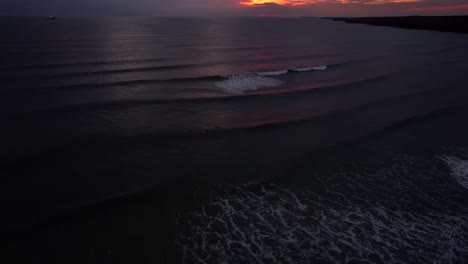 Impresionante-Puesta-De-Sol-Sobre-La-Costa-Galesa-Con-Surfistas-Y-Un-Barco-Solitario-En-El-Agua