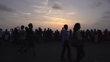 Touristenmenge-Genießt-Den-Sonnenuntergang-Am-Marine-Drive-In-Süd-Mumbai,-Silhouette-Von-Menschen-Gegen-Sonnenlicht