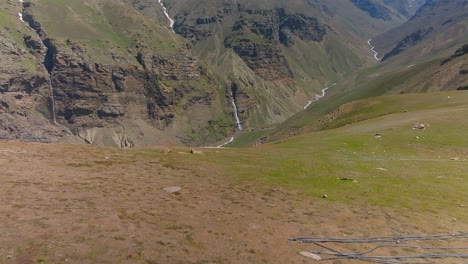 4K-Vorwärtsflug-Mit-Einer-Drohne,-Die-Eine-Himalaya-Schlucht-Mit-Einem-Fluss-Und-Mehreren-Wasserfällen-Zeigt,-Die-In-Den-Fluss-Münden