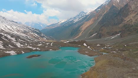 4K-Flyforward-Drohnenaufnahme-Eines-Teilweise-Gefrorenen,-Saphirblauen-Gletschersees-Im-Himalaya-Mit-Einem-Fluss,-Der-Aus-Dem-See-Entspringt