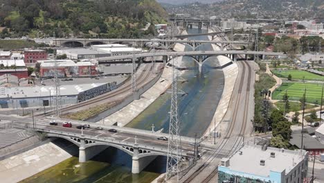 Cars-drive-over-bridges-along-the-historical-Los-Angeles-River,-aerial-view