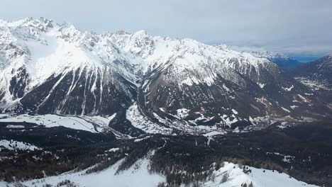 Eine-Atemberaubende-Luftaufnahme-Einer-Schneebedeckten-Bergkette-Mit-Steilen,-Schroffen-Gipfeln-Und-Bewaldeten-Tälern