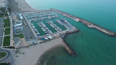 Aerial-orbital-shot-of-a-marina-with-boats-at-sunset