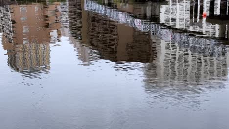 Los-Edificios-Se-Reflejan-En-Aguas-Tranquilas-Creando-Una-Escena-Urbana-Serena.