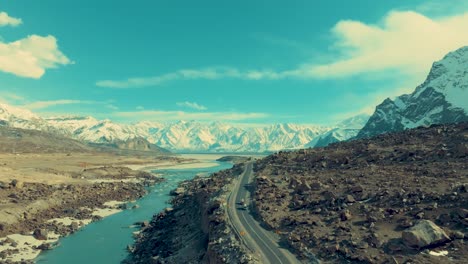 Wide-angle-shot-of-highways-leading-to-snow-covered-range-of-mountains-at-background-in-Skardu,-Pakistan