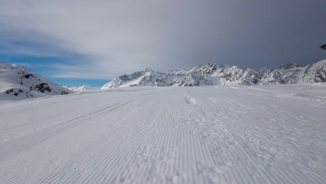 Drone-shot-over-a-snow-covered-slope-capturing-the-majestic-alpine-landscape-on-a-cloudy-day-during-winter-season,-Switzerland