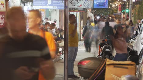 Timelapse-View-Of-Vibrant-city-street-scene-in-Malaysia,-filled-with-pedestrians-bustling-through-a-busy-night-market-area