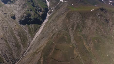 4K-Vorwärtsflug-Per-Drohne-über-Einen-Gefrorenen-Himalaya-Strom,-Der-Eisbedeckte-Gipfel-Enthüllt