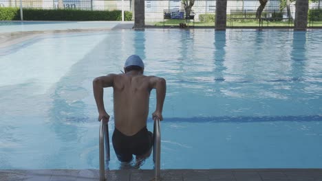 Swimmer-Walking-In-A-Pool-With-A-Ladder,-Dive-And-Doing-Crawl-Style-Swimming