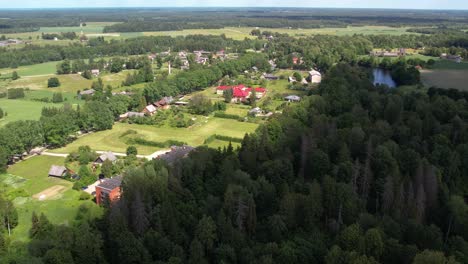 Aerial-view-of-Diklu-Stage-in-Dikli-village,-showcasing-the-open-air-performance-venue-surrounded-by-lush-greenery-and-nearby-buildings