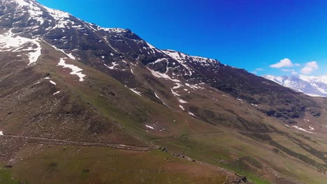 4K-fly-forward-DRONE-shot-revealing-mighty-Himalayan-mountains-with-snow-caps-and-hikers-trail