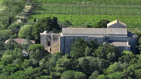 Maguelone-Cathedral-on-a-small-island-over-the-lagoon-with-sandbar-roads,-Wide-reveal-aerial-shot