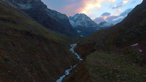 4K-Drohne-Fliegt-Vorwärts,-Aufnahme-Der-Schneebedeckten-Himalaya-Berge-Mit-Einem-Gletscherfluss-Und-Einem-Atemberaubenden-Sonnenaufgang