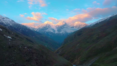 4K-Descending-DRONE-shot-of-Snow-capped-Himalayan-mountains-with-a-Golder-sunrise-sky