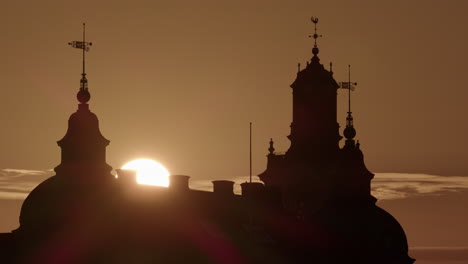 Sun-rising-in-vivid-sky-between-towers-of-Old-Parliament-House-on-Riddarholmen