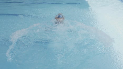 Back-View-Of-Swimmer-Wear-White-Cap-Jump-Into-Pool-And-Doing-Frog-Style-Swimming