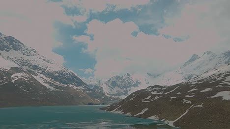 4K-flyforward-Drone-shot-of-Glacial-lake-surrounded-by-snow-capped-Himalayan-peaks-on-a-bright-day