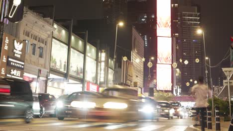 Escena-Nocturna-Vibrante-De-Timelapse-De-Una-Concurrida-Calle-Urbana-En-Malasia,-Con-Automóviles,-Peatones-Y-Luces-Brillantes-De-La-Ciudad