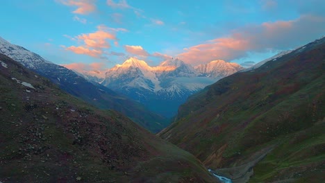 4K-drone-descending-shot-across-Himalayan-mountains-with-Sunlight-reflecting-on-the-snow-and-clouds