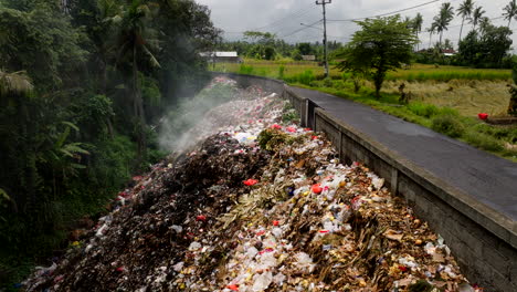 Basura-Humeante-En-La-Carretera-De-La-Carretera-Rural-De-Bali,-Plataforma-Rodante-Aérea-Baja