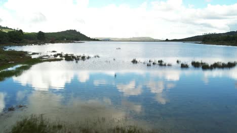 Vista-Aérea-Del-Pequeño-Lago-En-Las-Montañas