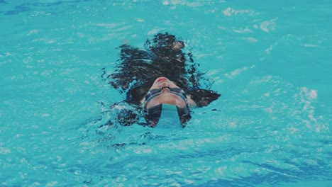 Closeup-Of-Asian-Female-Swimmer-Doing-Backstroke-In-Swimming-Pool