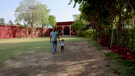 father-and-son-enjoying-outdoor-walk-at-evening-at-lawn