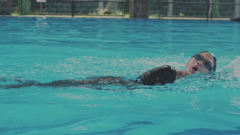 Side-view-Of-Young-Female-Swimmer-Doing-Freestyle-In-Swimming-Pool