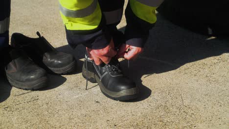 A-man-tying-his-shoelaces-wearing-a-high-visibility-vest