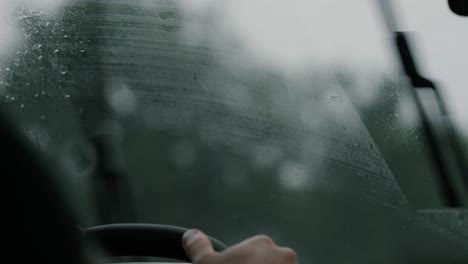 Gotas-De-Lluvia-En-El-Parabrisas-Con-Una-Escena-De-Conducción-En-Carretera-Borrosa