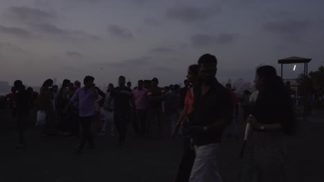 Crowd-of-tourists-at-Marine-Drive-beach-after-sunset-under-stormy-sky