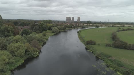 Tiro-Aéreo-Hacia-Atrás-Sobre-El-Río-Trent-Con-Las-Torres-De-Enfriamiento-De-La-Central-Eléctrica-De-Willington-En-La-Distancia