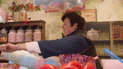 kiosk-owner-bagging-up-candy-floss-and-twirling-around-the-bag-to-seal-it