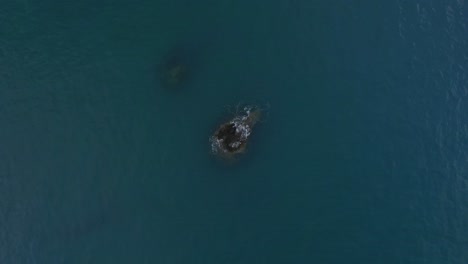 Aerial-view-of-a-rock-over-a-calm-blue-caribbean-sea