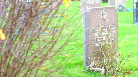 Shared-grave-by-a-couple-in-Kviberg-Cemetery-in-Gothenburg,-Sweden---Tombstone---focus-pull