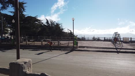 Dos-Trabajadores-Limpiando-La-Carretera-Asfaltada-De-La-Basura-Usando-Una-Barredora,-En-Un-Día-Soleado,-En-Un-Pequeño-Pueblo-Llamado-Chrea,-En-Argelia