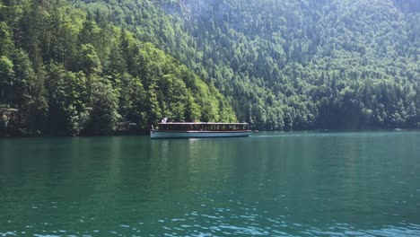 Tourist-Boat-sailing-across-Koenigsee-Lake-in-front-of-the-Alps-in-a-beautiful-summer-day