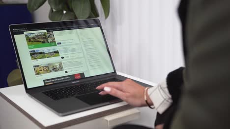 Women-scrolling-through-real-estate-properties-on-a-laptop