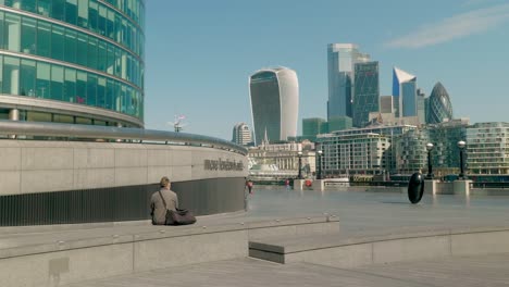 Old-man-sitting-alone-watching-London's-Skyline-during-the-Covid-pandemic,-London,-UK