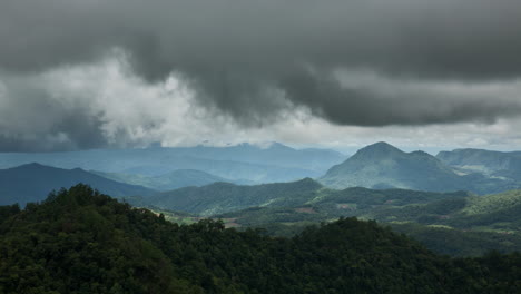 rain-accumulating-clouds-moving-fast-over-lush-green-tropical-mountain-scenery,-timelapse