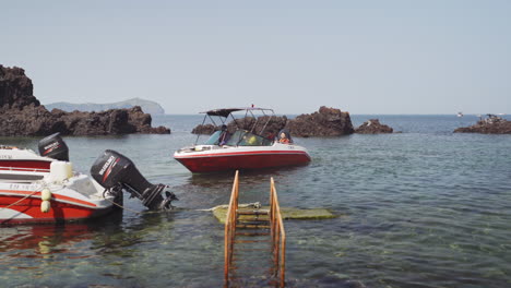 Tourists-going-for-a-boat-ride-off-the-coastline-of-Seongsan-Ilchulbong-Peak,-Jeju-Island,-South-Korea,-medium-track-in-4K