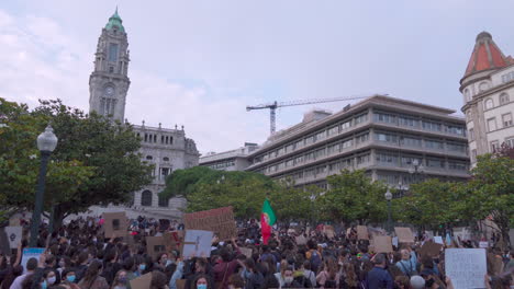 Porto---Portugal---6.-Juni-2020:-BLM-Protestdemonstration-„Black-Lives-Matter“-Mit-Demonstranten,-Die-Schilder-Der-„Black-Lives-Matter“-In-Die-Luft-Halten,-Im-Hintergrund-Das-Rathaus-Und-Die-Portugiesische-Flagge